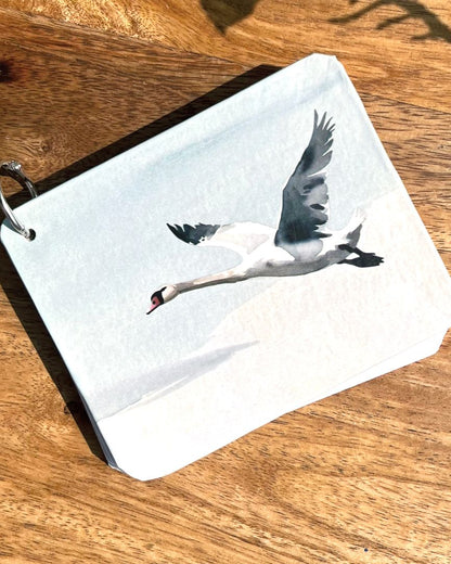 Small journal with a swan design on a wooden surface